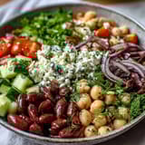 Bright Greek Bean Salad with lemon marinated beans, crisp cucumber, and sweet tomatoes, topped with creamy crumbled feta.
