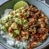 Vibrant chicken tinga bowl featuring tender chipotle-spiced chicken thighs, colorful bell peppers, and fresh lime-avocado salsa.  