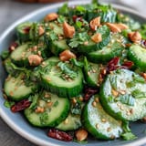 Light and tangy Asian Cucumber Salad with Sesame and Rice Vinegar, featuring thinly sliced cucumbers and a flavorful rice vinegar dressing.