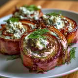 Bite-sized ham and cream cheese pinwheels with tangy pickles, perfect for party platters or quick snacks.