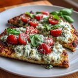Enjoy this high-protein cottage cheese flatbread loaded with vibrant pesto and ripe tomatoes.