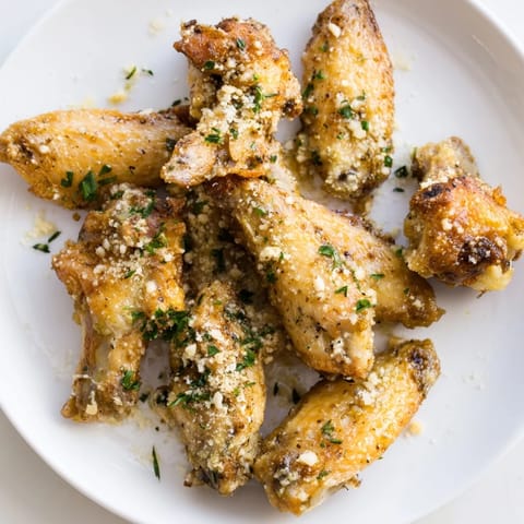 Golden-brown Garlic Parmesan Wings, crispy from the oven, ready to serve with extra cheese.