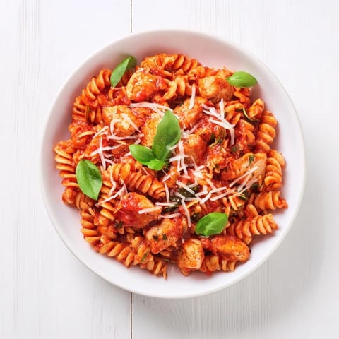 Bright chunks of tender chicken and al dente penne coated in a vibrant, chunky tomato basil sauce, topped with fresh basil and grated Parmesan.