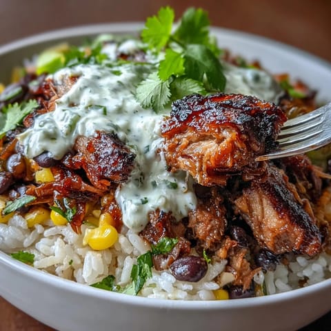 Colorful carnitas burrito bowl with tender shredded pork, fluffy rice, black beans, sweet corn, crisp lettuce, fresh salsa, and tangy lime crema, garnished with cilantro and lime wedges.