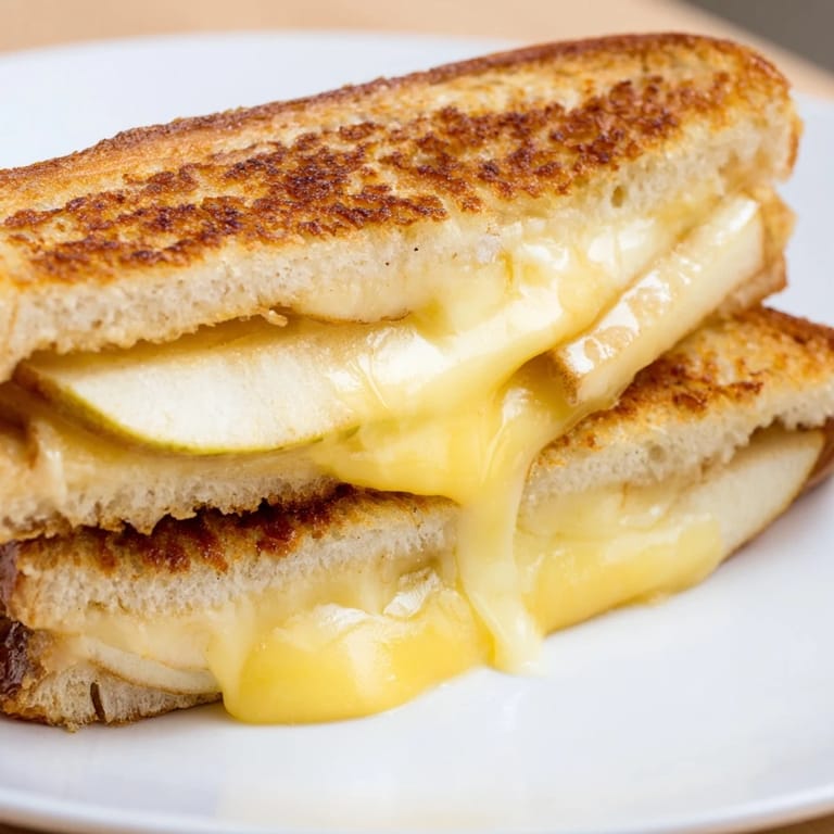 Buttery sourdough bread encases warm Smoked Gouda & Apple Grilled Cheese, with sharp apple slices peeking from the melty interior.